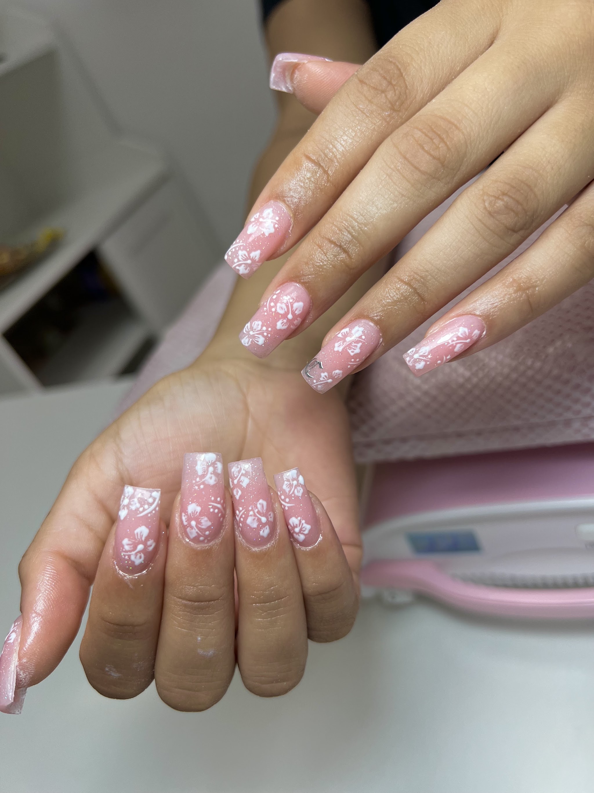 Korte lichtroze French nagels met witte bloemetjes