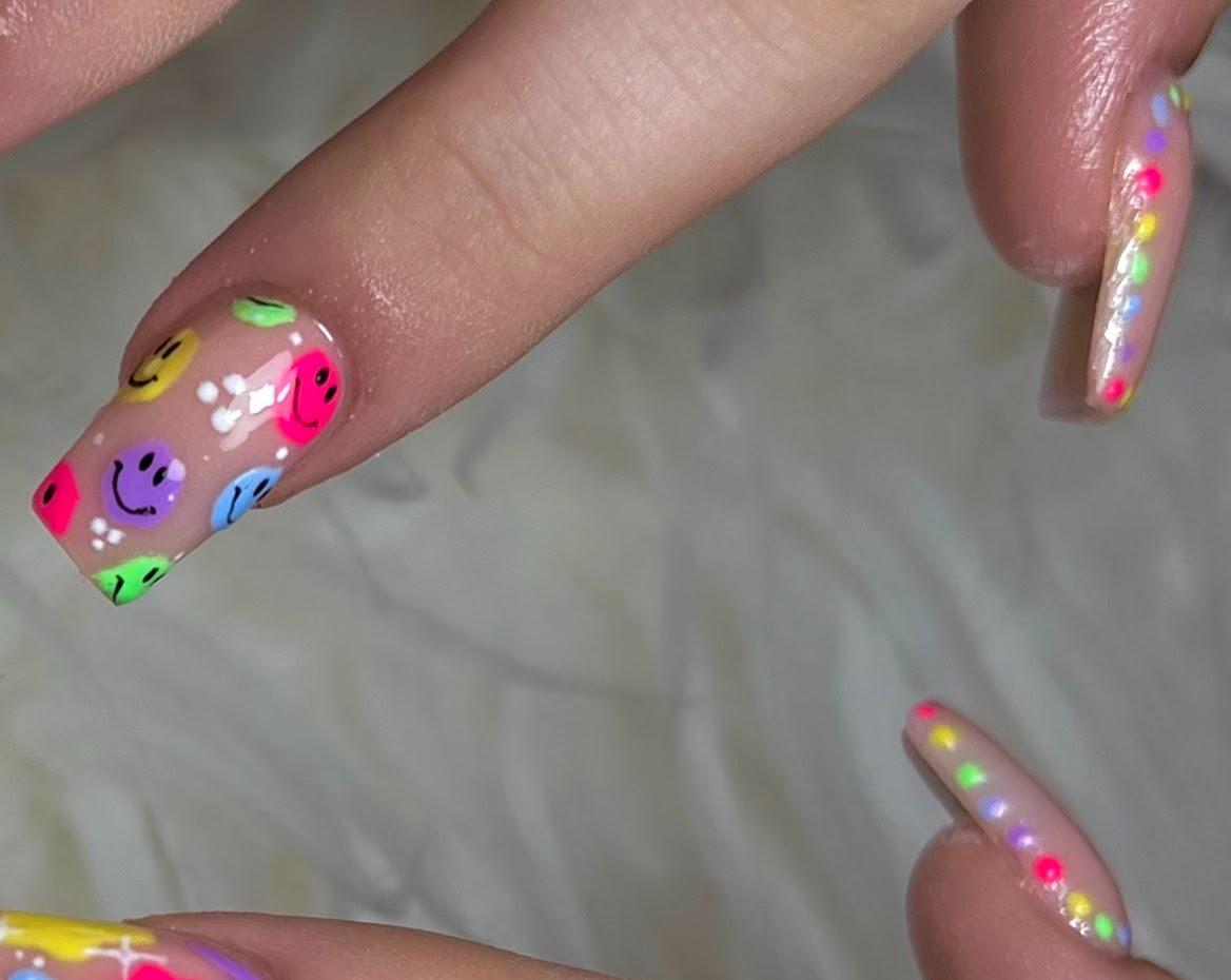 Kleurrijke smiley nail art op witte vacht