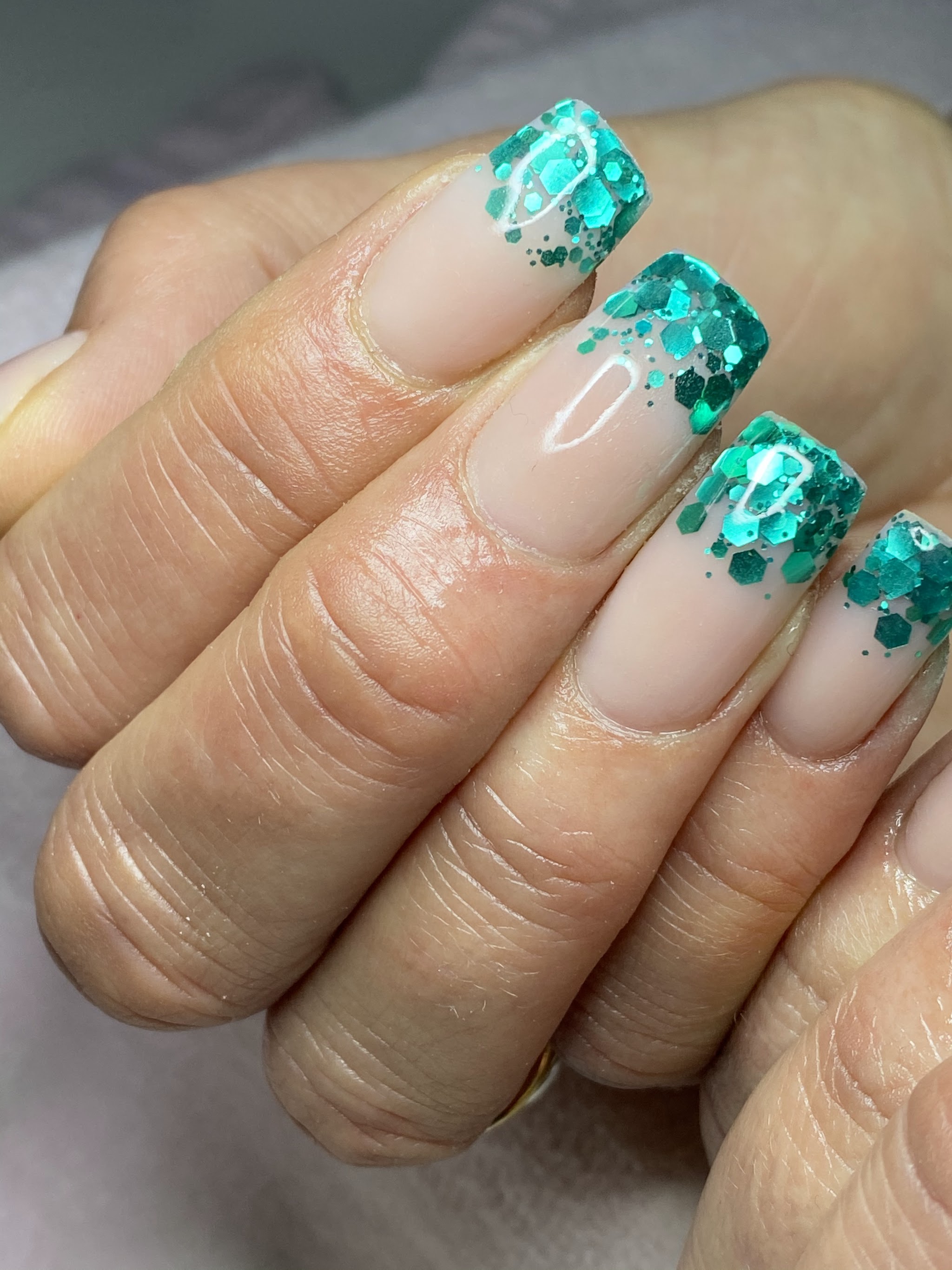 Natuurlijke nagels met turquoise glitter French tips