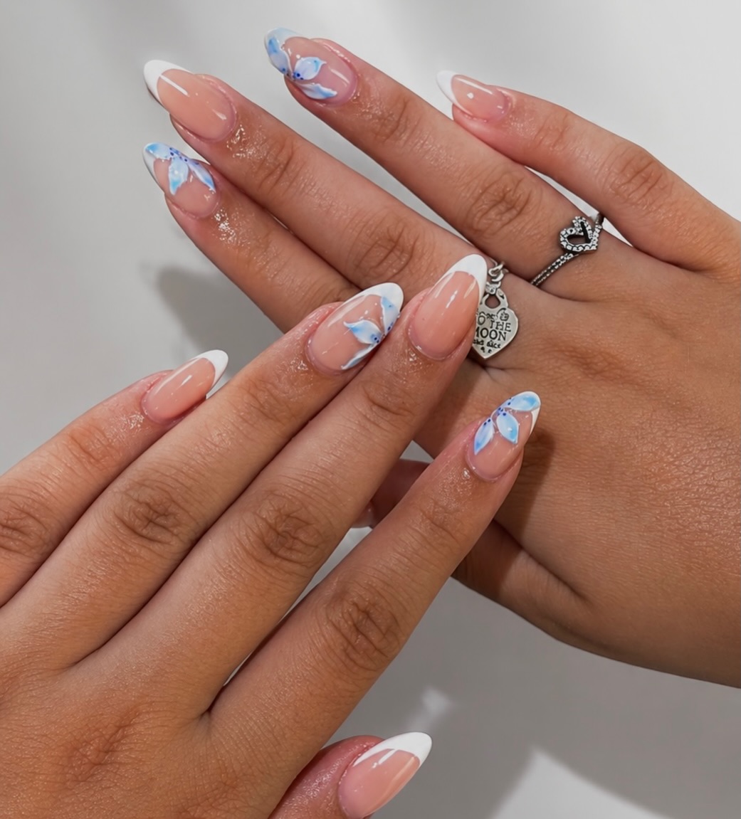 Witte French almond nagels met blauwe bloemaccenten