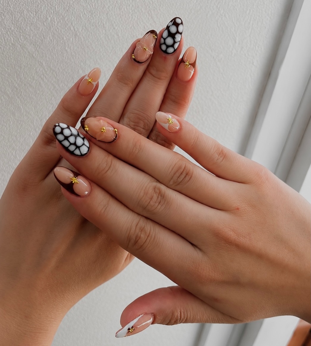 Zwart-witte koeienprint nagels met gouden charms